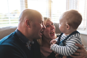 Happy family portrait with parents laughing and looking at their son