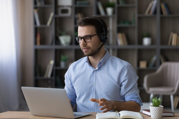 Wall Mural - focused businessman in glasses and wireless headset with microphone making video call, consulting cl