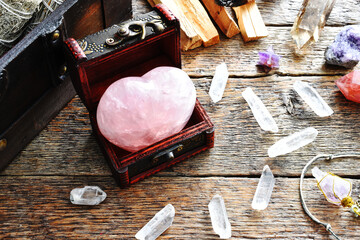 Wall Mural - A top view image of a heart shaped rose quartz crystal in a small wooden box. 