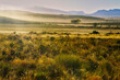 © geoffsp - Backlit landscape of grass, hills, and mountains