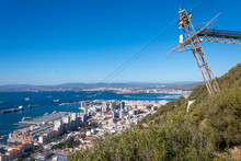 View Of The Gibraltar Cable Car Aerial Tramway In Gibraltar Which Travels Up The Rock Of Gibraltar With Views Of The City, Sea And Bay Of Gibraltar, UK.