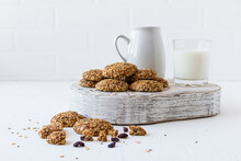 Oatmeal Biscuits On A White Wooden Podium With A Glass Of Milk, A Jug Opposite A White Brick Wall. Delicious, Healthy.