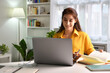 © amenic181 - Smiling and feeling positive. happy young Asian woman freelancer working on computer at home. Attractive businesswoman studying online, using laptop software, web surfing information or shopping