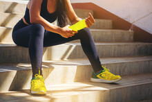 Tired Runner Woman With A Bottle Of Electrolyte Drink Freshness After Training Outdoor Workout At The Stadium Stairway.