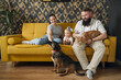 © Westend61 - Smiling family with baby girl and pets in living room