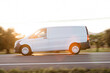 © Westend61 - Delivery man driving van on road at sunset