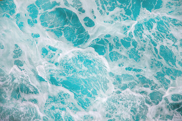 Wall Mural - Raging sea with foam on the crest of a wave. Blue water background