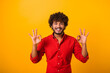 I am ok. Portrait of cheerful brown-haired man with beard and mustache in casual shirt looking at camera and showing okay hand gesture. Indoor studio shot isolated on orange background