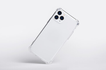 Wall Mural - Silver iPhone 11 and 12 Pro max in clear silicone case falls down back view, phone case mockup isolated on gray background