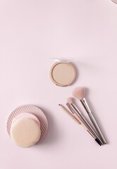 Wall Mural - Make up layout, accessories and face powder on pastel pink background. Minimal and luxury make up, cosmetic or beauty salon composition. Flat lay, top view, copy space.