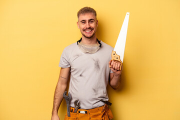 Wall Mural - Young electrician caucasian man isolated on yellow background happy, smiling and cheerful.