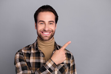 Wall Mural - Photo of pretty cute man wear plaid shirt pointing empty space smiling isolated grey color background
