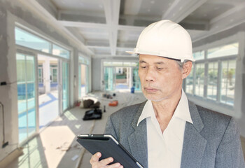 Wall Mural - senior Asian construction architect inspecting the workplace.