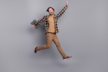 Poster - Full length body size view of attractive funny cheerful guy jumping holding laptop having fun isolated over grey color background