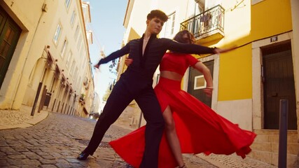 Wall Mural - Beautiful Couple Dancing a Latin Dance on the Quiet Street of an Old Town in a City. Sensual Dance by Two Professional Dancers on a Sunny Day Outside in Ancient Culturally Rich Tourist Location.