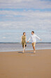 © MyJuly - a couple of a man and a woman are walking on the beach or running along the sand along the seashore. beautiful and young European man and woman on a romantic walk in nature, a couple in love, a happy