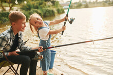 Having Fun. Boy With His Sister In On Fishion Outdoors At Summertime Together