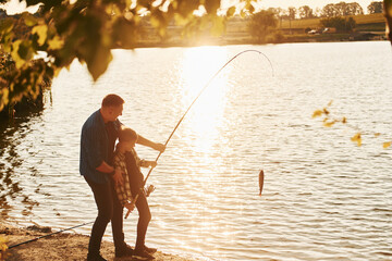 Wall Mural - With catch. Father and son on fishing together outdoors at summertime