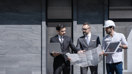 businessman or owner meeting building consults engineering team design of the building solar cell system or energy engineer plan project under construction. clean and green alternative energy concept.