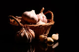 Fototapeta Tulipany - Czosnek w koszyku. Tło przedstawiające cały czosnek oraz ząbki czosnku na czarnym tle. Zdrowa żywność, jako tapeta lub tekstura na przepis kulinarny. całość lub przyprawa do potraw.