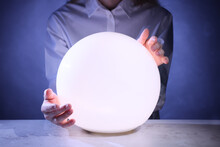Businesswoman Using Glowing Crystal Ball To Predict Future At Table, Closeup. Fortune Telling