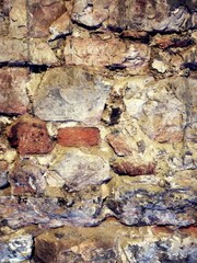 Stones and rocks. An old crumbling wall with a beautiful, rough structure. 