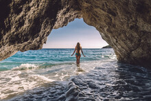 Woman In Natural Cave Agains Sea On Gjipe Beach