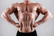 © Evrymmnt - Professional bodybuilder posing over isolated white background. Front Lat Spread pose. Studio shot of a fitness trainer flexing the muscles. Close up, copy space.
