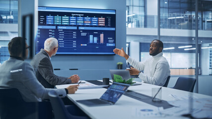 Wall Mural - Modern Office Conference Room Businesspeople Meeting: Black Digital Entrepreneur Talks with Caucasian Executive and Investor, They Talk, Discuss Investment Strategy, Use TV Screen with Infographics