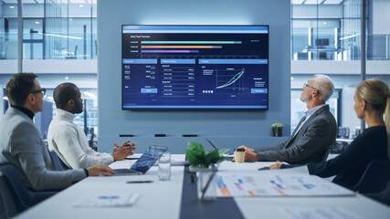 Wall Mural - Office Conference Room Meeting: Group of Professional Entrepreneurs, Investors Talk, Use TV Screen with Infographics, Analysing Charts, Graphs, Statistics. Businesspeople Discuss Investment Strategy