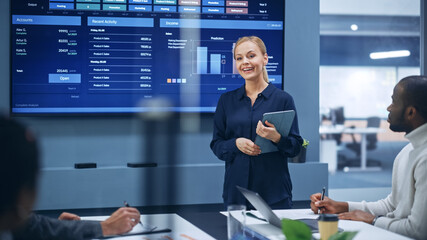 Leinwandbilder - Diverse Modern Office: Portrait of Successful Caucasian Businesswoman Uses TV Screen with Big Data, Statistics, Talks about Company Growth. Creative Digital Entrepreneurs Work on e-Commerce Project