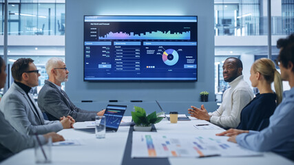 Leinwandbilder - Office Conference Room Meeting Presentation: Black Businessman Talks, Uses Wall TV to Show Company Growth with Big Data Analysis, Graphs, Charts, Infographics. Multi-Ethnic e-Commerce Startup Workers