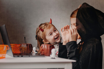 Kids wear Halloween costumes having fun at home.