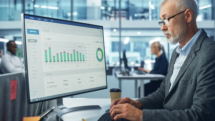Poster - Corporate Office: Senior IT Specialist Using Desktop Computer with Big Data Statistics, Graphs. Smiling Creative Software Engineer Work on eCommerce Project Marketing, Development.