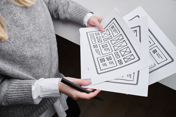 Woman designer create website design wireframe. Sketch, prototype, framework, layout future design project. UI and UX - user interface, user experience designer. Creative concept for web design studio