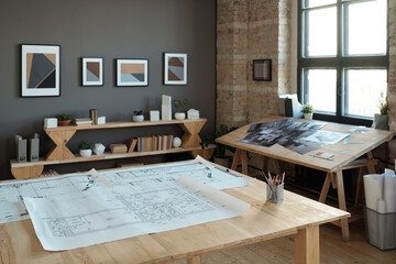 Poster - Group of blueprints with architectural sketches on large wooden table in contemporary office or workshop