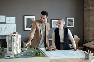 Poster - Two professional engineers and architects discussing house layout while one of them making presentation of new project
