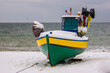 kuter rybacki wyciągnięty na plaże zimą