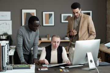 Poster - Group of contemporary intercultural architects or designers discussing papers with interior photos by workplace