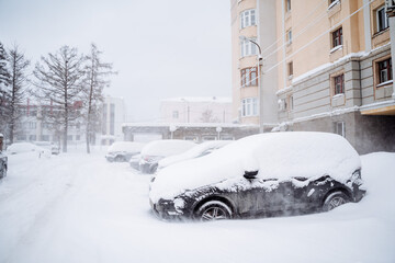 The car is buried under a layer of snow. Heavy snowfall in the city. The equipment stands under a snowdrift. Consequences of a winter hurricane.