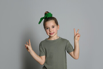 Poster - Cute little girl with stylish bandana on grey background