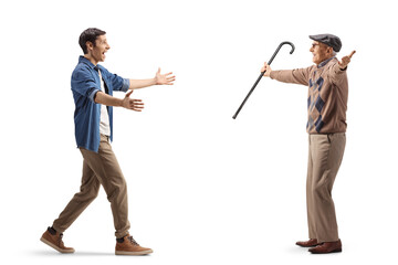 Wall Mural - Full length profile shot of a happy young man walking towards an elderly man with arms wide open