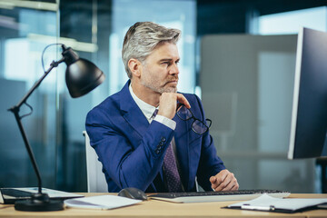 Wall Mural - Portrait of a man, businessman thinking while working in the office at the computer