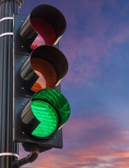 Concept of hope and positivity with a traffic signal on green set against a sunrise or sunset