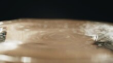 A Drop Of Water In Slow Motion Falls Into The Water On A Black Background, Close-up