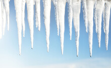 Large Icicles Close-up. Clear Blue Sky. Concept Winter Landscape. Midday Sun. Seasons, Ecology, Environment, Climate Change, Global Warming, Anomaly, Nature. Panoramic View, Copy Space