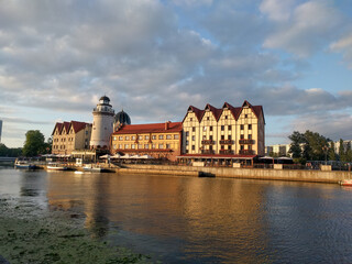 Wall Mural - The Fishing Village and lighthouse on the banks of Pregolya River at sunset light, Kaliningrad, Russia