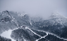Fantastic Winter Landscape With View On Ski Trails And Small Cliff Restaurant House. Fog Over The Hills.
