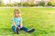 © Iván Moreno - little boy sitting on grass of a park looking away