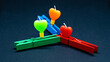 The real heart-shaped candle is clamped with a clothespin. clothes peg clamped clamp light burn isolated colorful  
Orange green pink blue red lightblue 